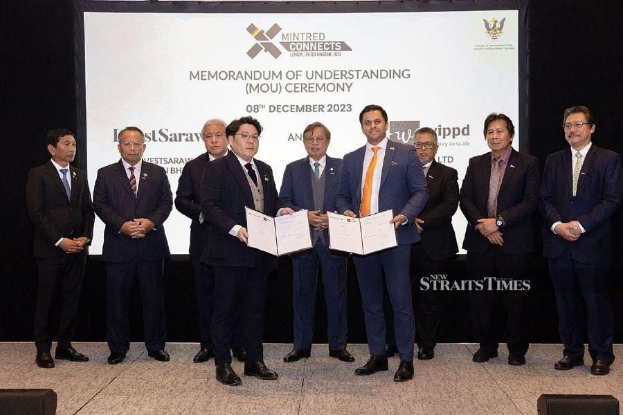 Sarawak Premier Tan Sri Abang Johari Abang Openg (centre) witnessing the exchange of documents after the signing of a memorandum of understanding between Invest Sarawak Sdn Bhd and WWIP Ltd in London.