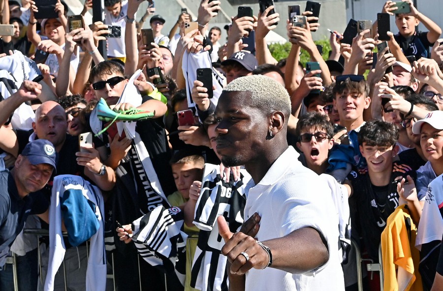 French World Cup winning midfielder Paul Pogba greeting supporters as he arrives to the Juventus football club's Medical Center, in Turin. - AFP PIC 