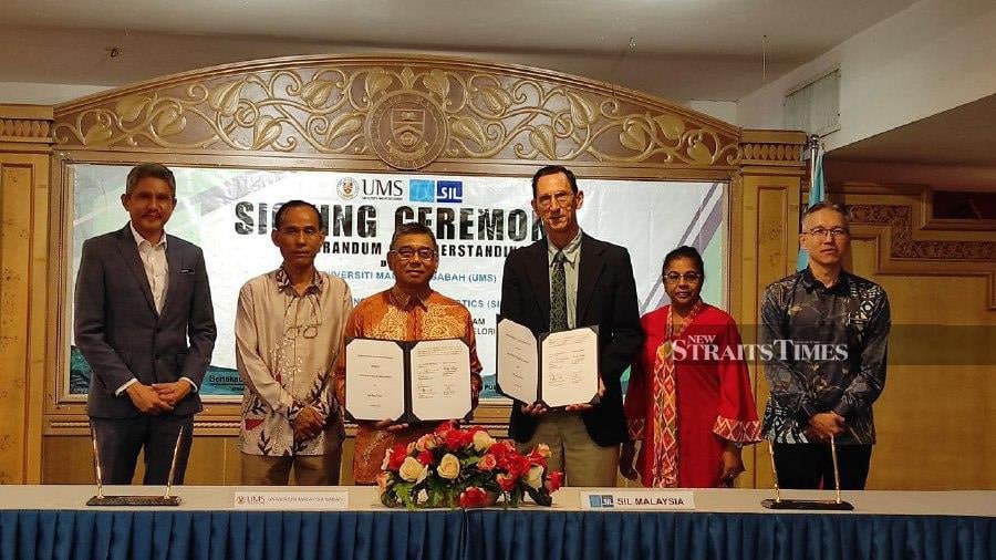 Summer Institute of Linguistics (SIL) Malaysia Executive Director Dr Timothy Philips (third right) and UMS Vice-Chancellor Professor Datuk Dr Kasim Mansor (third left) during the Memorandum of Understanding (MoU) signing ceremony. -NSTP/Ersie Anjumin