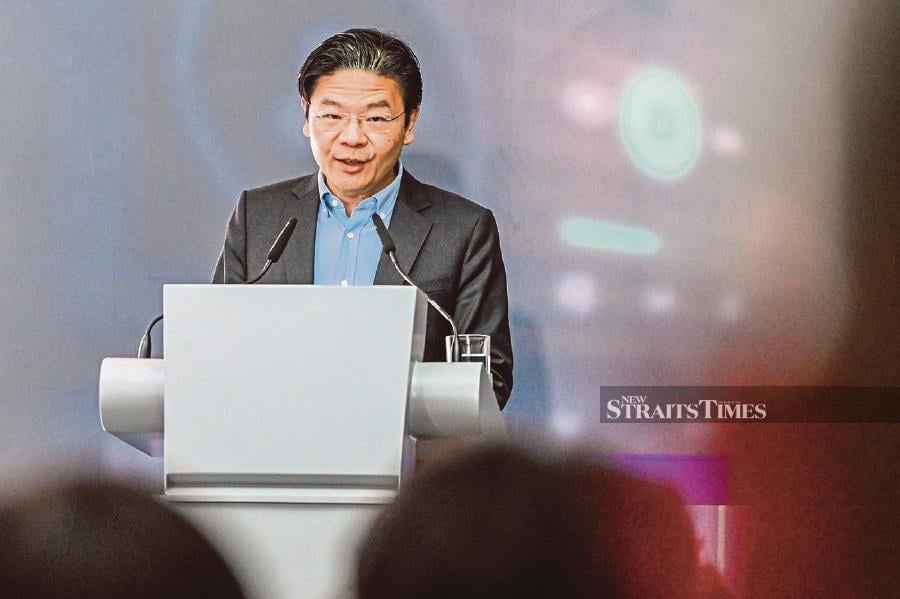 Singapore's Deputy Prime Minister and Minister for Finance Lawrence Wong delivers a speech (Photo by Roslan RAHMAN / AFP)