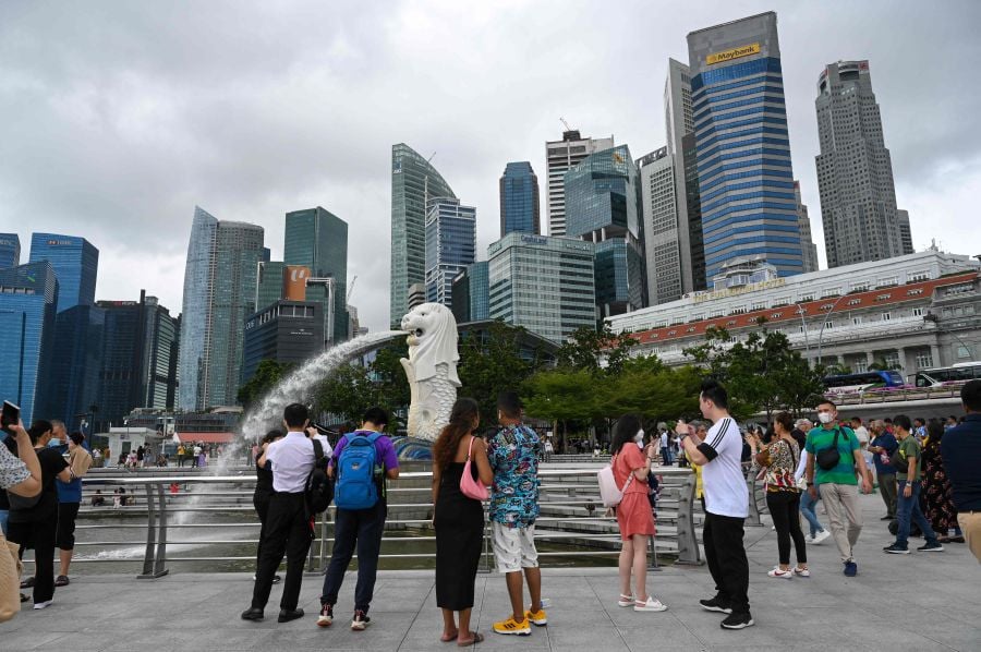People gather at the Merlion park along Marina Bay in Singapore. (Photo by Roslan RAHMAN / AFP)