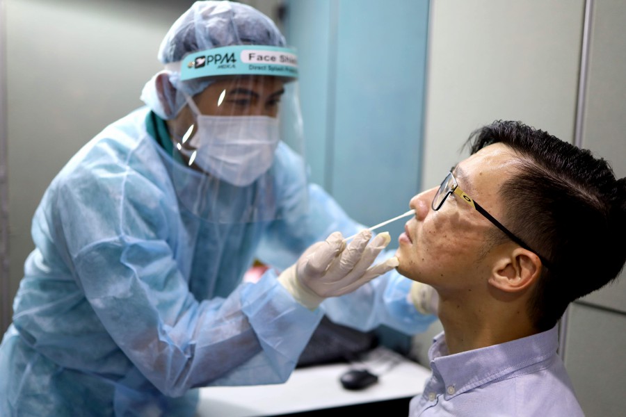 This handout from the Raffles Medical Group shows an MMA fan getting a nose swab at a clinic before being cleared to watch the "One: Inside the Matrix" MMA fight card in Singapore. AFP pic
