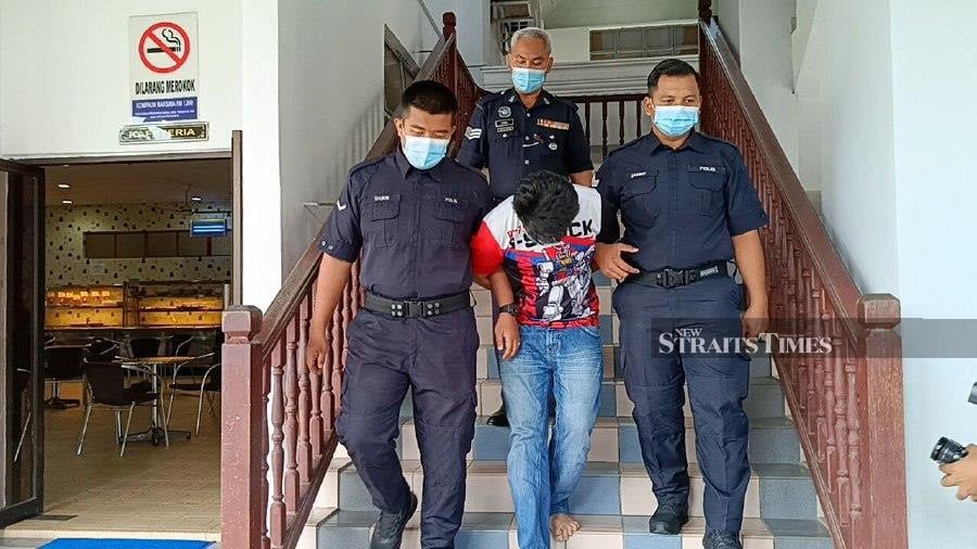  Muhammad Shahrul Helmi (centre) is escorted by policemen at the Ayer Keroh magistrate’s court after the trial.- NSTP/Meor Riduwan Meor Ahmad.