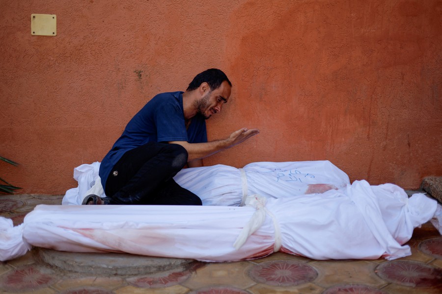 Palestinian man Mohammed al-Akhras reacts next to the bodies of his daughter Jana and his wife who were killed by Israeli strikes in Khan Younis in the southern Gaza Strip. - REUTERS PIC