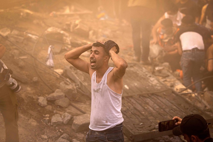 A Palestinian man reacts as others check the rubble of a building in Khan Yunis. - AFP PIC