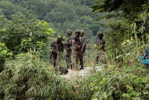 South Korean army soldiers search for a South Korean soldier who is on the run after a shooting incident in Goseong, South Korea, Sunday, June 22, 2014. The military searched Sunday for an armed South Korean soldier who fled after killing five of his comrades and wounding seven at an outpost near the North Korean border. AP Photo