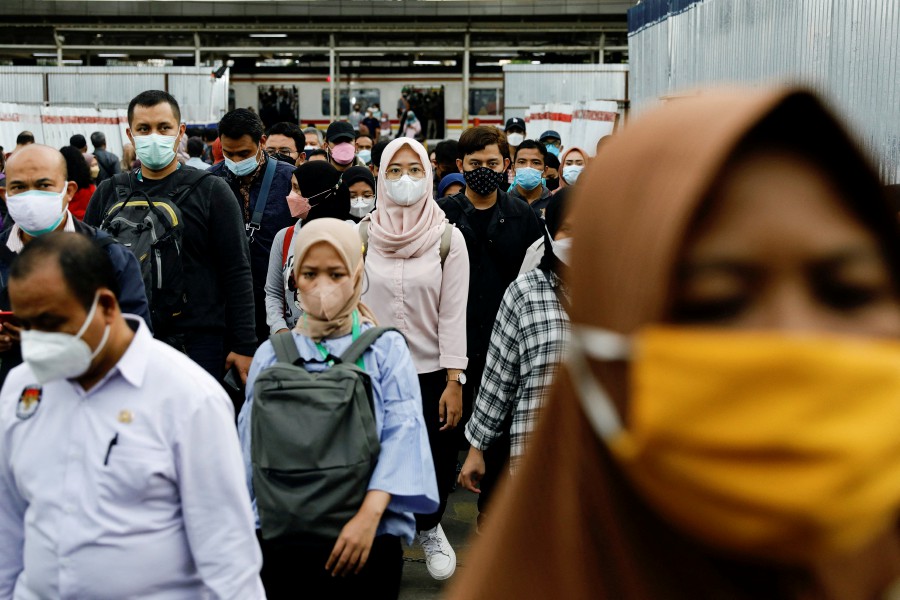  People wearing protective masks walk through a platform of a train station during the afternoon rush hours as the Omicron variant continues to spread, amid the Covid-19 pandemic, in Jakarta, Indonesia,  on January 3, 2022. - REUTERS PIC