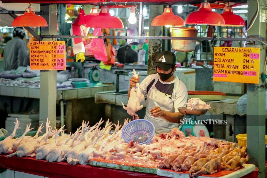  A trader selling chicken at RM9.50 per kg at a market in Kuala Lumpur yesterday. -NSTP/ASYRAF HAMZAH