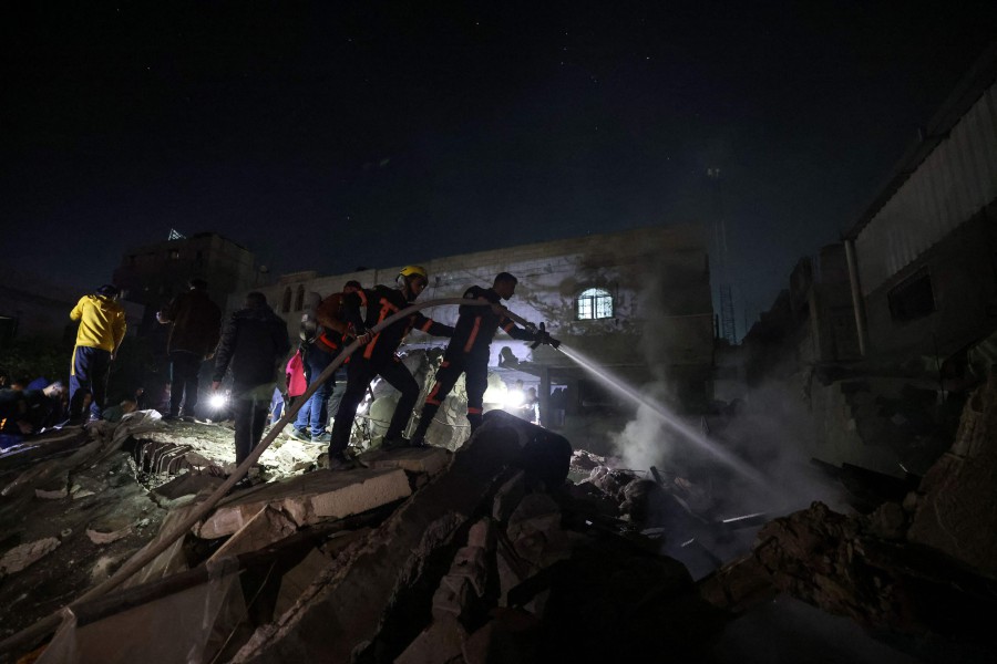 Firefighters spray water on the rubble of a building following Israeli bombardment in Rafah, in the southern Gaza Strip. - AFP PIC