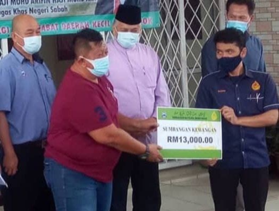 Menumbok-Labuan Speedboat Association chairman Mohamad Sait (left)  receiving a mock cheque from Sabah Baitulmal Corporation general manager Salam Nurilah (right) as state Special Tasks Minister Datuk Arifin Arif (centre) and other guests looks on. - Pic courtesy of  JAAFAR ABD WAHID