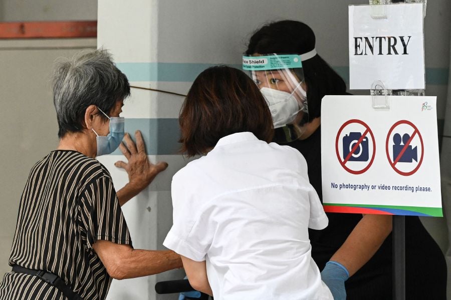 An elderly resident arrives to get tested at a temporary swab centre set up at the void deck area on the ground floor of a public housing block, after a few positive Covid-19 coronavirus cases were detected in the building, in Singapore on May 21, 2021.  - AFP FILE PIC