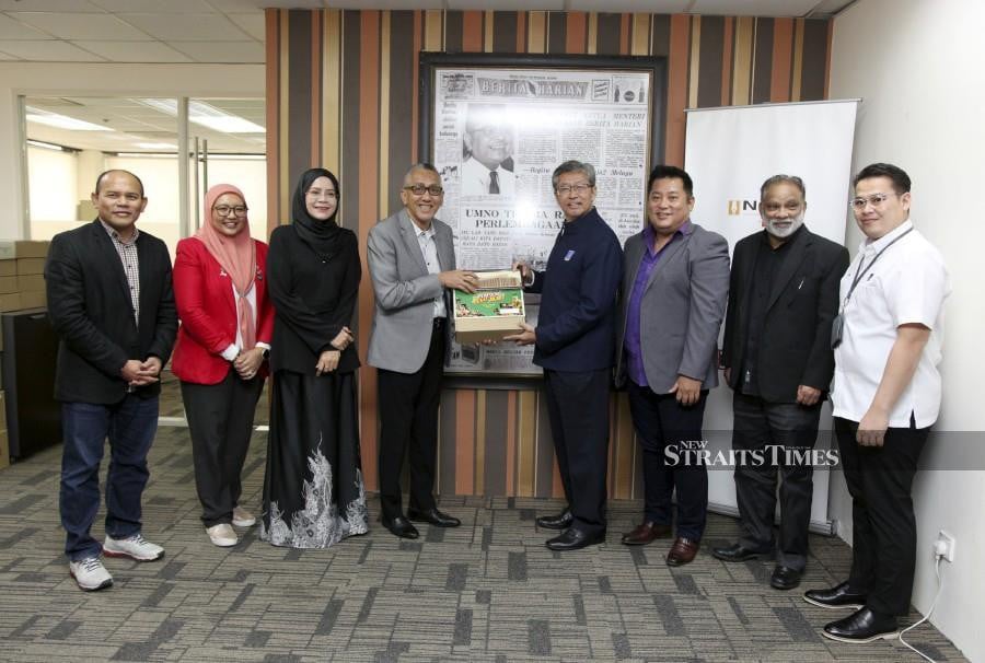 SIRIM Bhd president and group chief executive officer Datuk Dr Ahmad Sabirin Arshad (fourth from right) passing a token of appreciation to New Straits Times Press group managing editor Datuk Ahmad Zaini Kamaruzzaman. Witnessing the exchange are NST group editor Farrah Naz Karim (third from left), ‘Harian Metro’ group editor Husain Jahit (left) and ‘Berita Harian’ deputy group editor M. Thilinadan (second from right). -NSTP/IKHWAN MUNIR