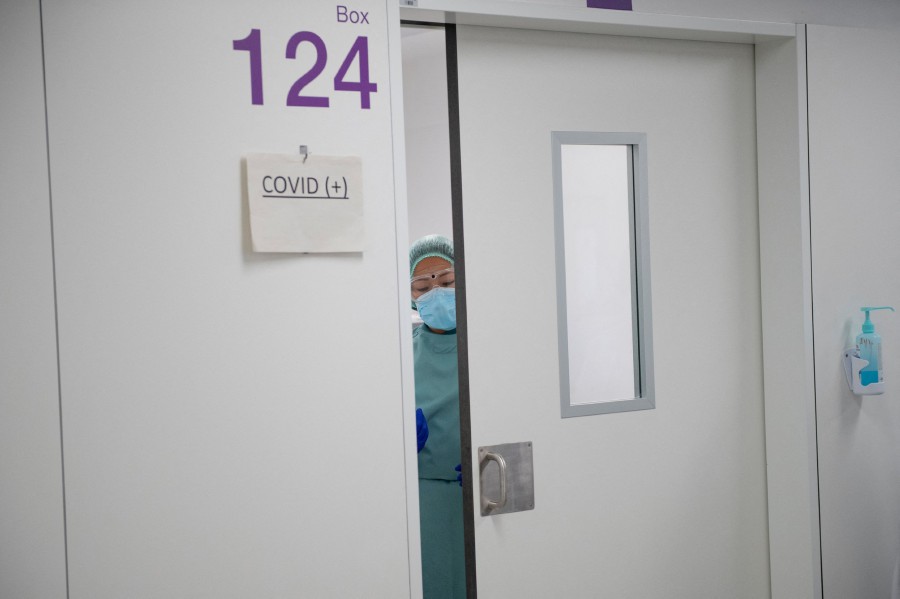 A healthcare worker closes a door at the semi-critical respiratory unit of the Bellvitge University Hospital in Barcelona. - AFP PIC