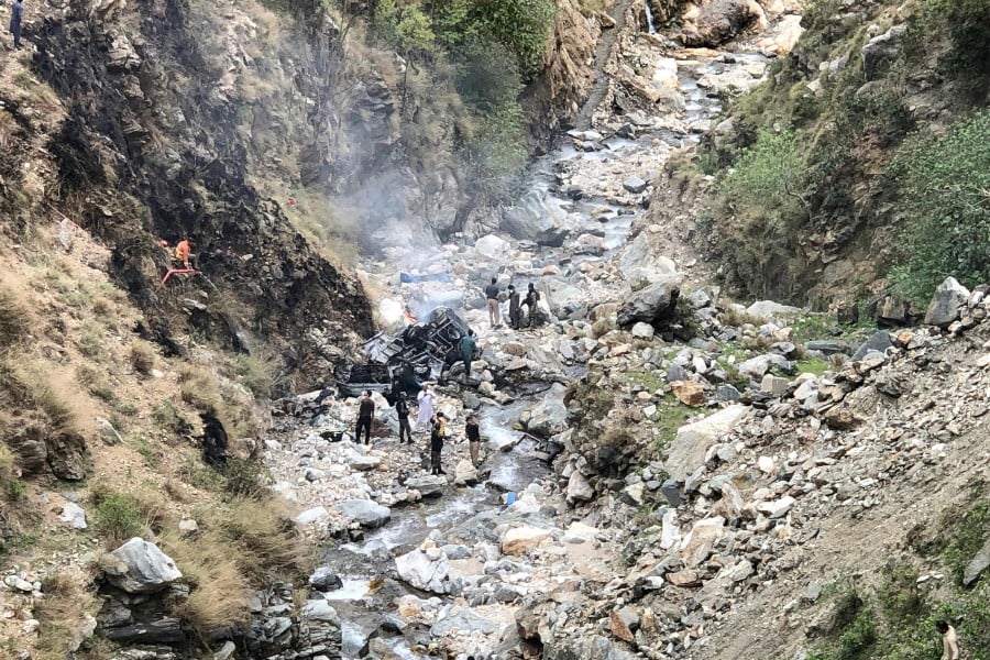 Security officials inspect the wreckage of a vehicle which was carrying Chinese nationals that plunged into a deep ravine off the mountainous Karakoram Highway after a suicide attack near Besham city in the Shangla district of Khyber Pakhtunkhwa province on March 26, 2024. -- Pic: AFP