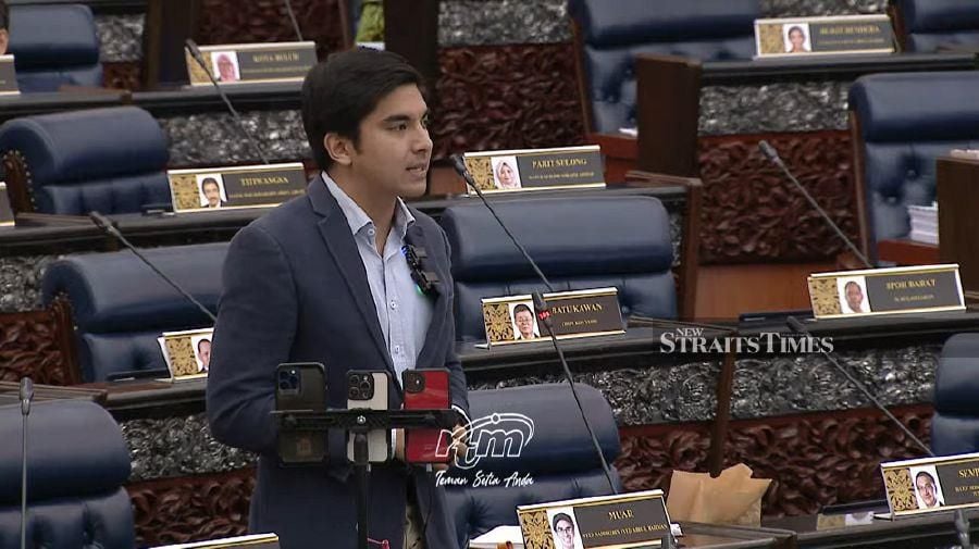 Muar MP Syed Saddiq Syed Abdul Rahman speaks during the Dewan Rakyat sitting. The lawmaker had utilised three phone cameras to live stream his speech. 