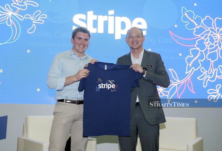 Stripe co-founder and president John Collison (left) presents a souvenir to Deputy International Trade and Industry Minister, Dr Ong Kian Ming during the launch in Kuala Lumpur. -NSTP/Zulfadhli Zulkifli.
