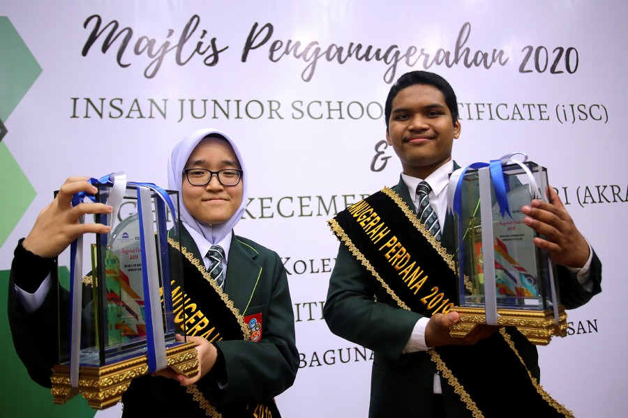 Maryam (left) and Hasnul proudly hold up their Aqbari Perdana trophies at USIM today. Bernama pic