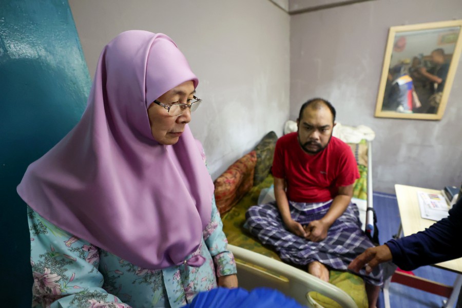 Bandar Tun Razak MP Datuk Seri Dr Wan Azizah Wan Ismail (left) visiting Nor Aliff Mohd Nor, 37, a person with a disability who is suffering from various illnesses at Perumahan Awam Sri Johor today. -- BERNAMA PIC