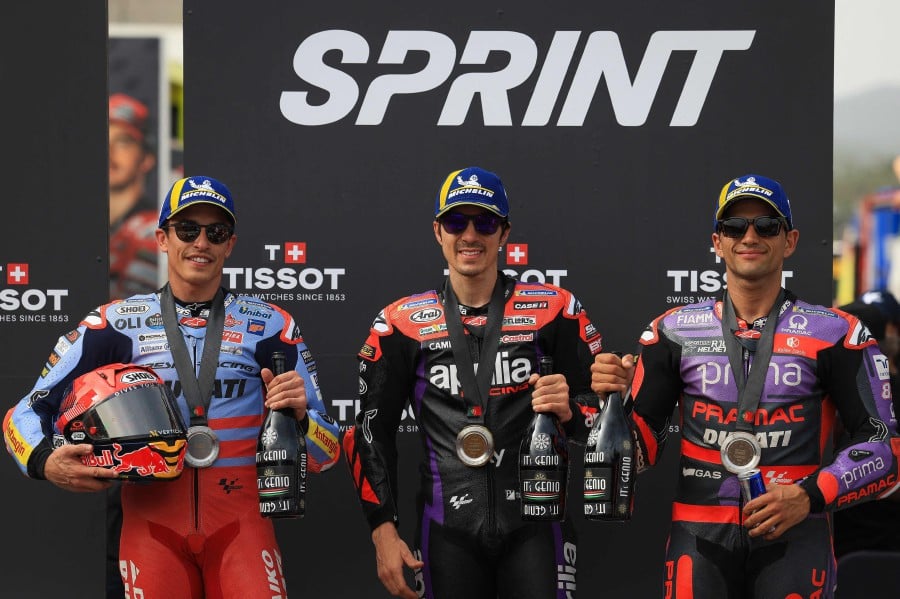 Winner Aprilia Spanish rider Maverick Vinales (C), second-placed Ducati Spanish rider Marc Marquez and third-placed Ducati Spanish rider Jorge Martin pose for pictures after the MotoGP sprint race of the Portuguese Grand Prix at the Algarve International Circuit in Portimao on March 23, 2024. -- AFP
