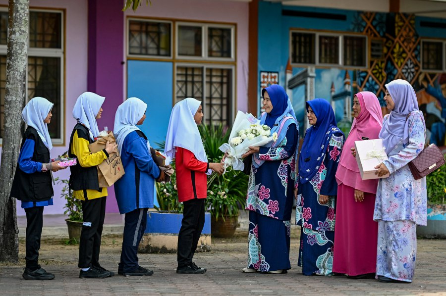  MARANG: Teachers from SK Simpang Rawai, including Rohaya Sidek (fourth from the right), Rozita Mohamad, Rosmani Abdul Rahman, and Norjahan Mohd Nor, receive gifts from their students in celebration of Teacher's Day. - BERNAMA PIC 