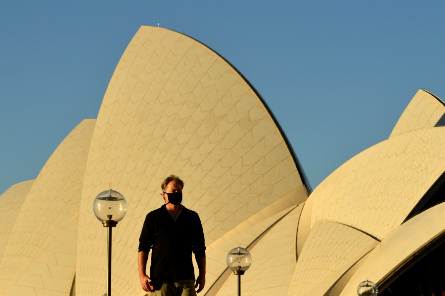 A pedestrian walks past the Sydney Opera House at sunset in Sydney, New South Wales (NSW), Australia. - EPA PIC