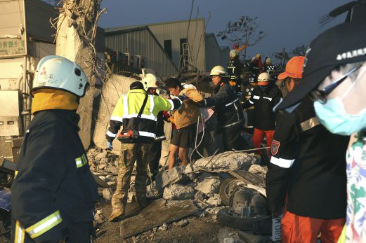 Firemen rescue a man from a collapsed house in Tainan City. EPA