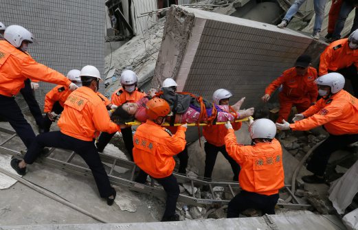 Rescuers carry a survivor from a collapsed building. EPA