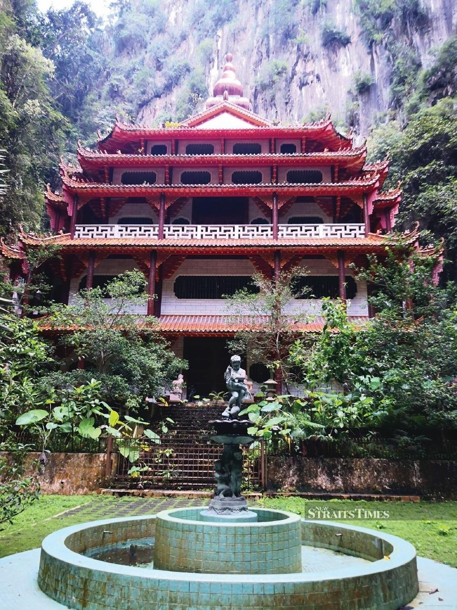 The temples are set against towering limestone outcrops and lush greenery.
