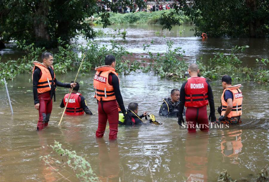 Firemen conduct a search and rescue mission to locate the teenager at Sungai Tok Hakim, Kampung Tok Hakim. - NSTP/GHAZALI KORI
