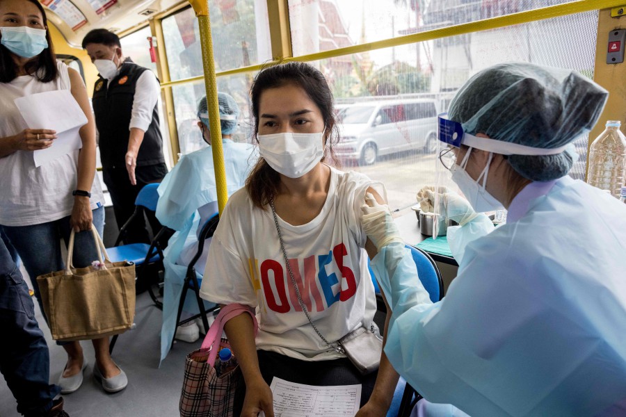 A woman receives a dose of the AstraZeneca/Oxford Covid-19 coronavirus vaccine in a "Mobile Vaccination Unit" set up inside a bus in Bangkok on September 8. - AFP PIC