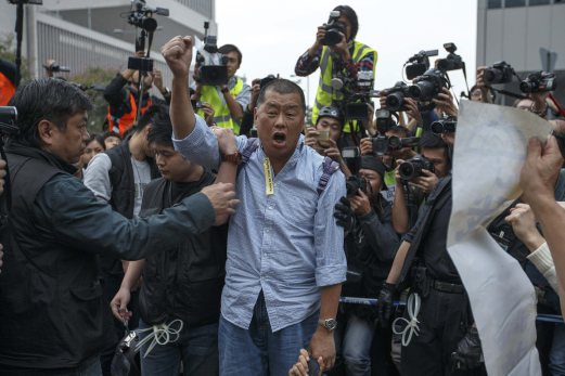 Tycoon and Apple Daily Newspaper owner Jimmy Lai shouts slogan before he is taken away by police officer at an area previously blocked by pro-democracy supporters, outside the government headquarters in Hong Kong. REUTERS 