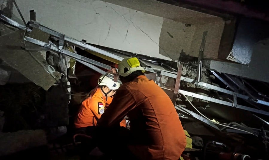 Rescuers searching for victims under the rubble of a collapsed building following a 6.2 magnitude earthquake in Mamuju, West Sulawesi, Indonesia. - Epa/Basarnas/Handout