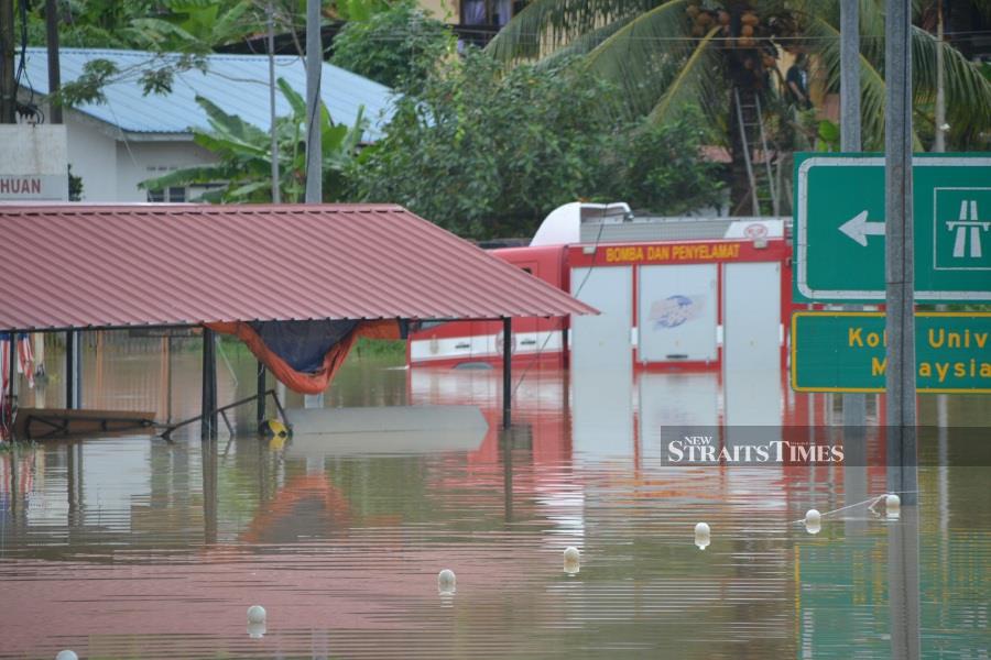 A fire engine seen stuck in floodwaters in front of Lubok Cina police station in Masjid Tanah. - NSTP/HASSAN OMAR