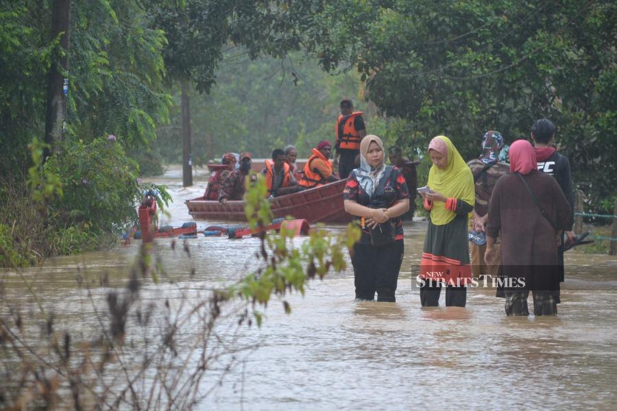 Firemen help evacuate flood victims in Lubok Cina, Masjid Tanah - NSTP/HASSAN OMAR