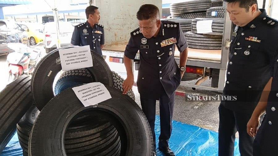Kuantan police chief Assistant Commissioner Wan Mohd Zahari Wan Busu (middle) inspecting the stolen tyres at the district police station. - NSTP/ Asrol Awang