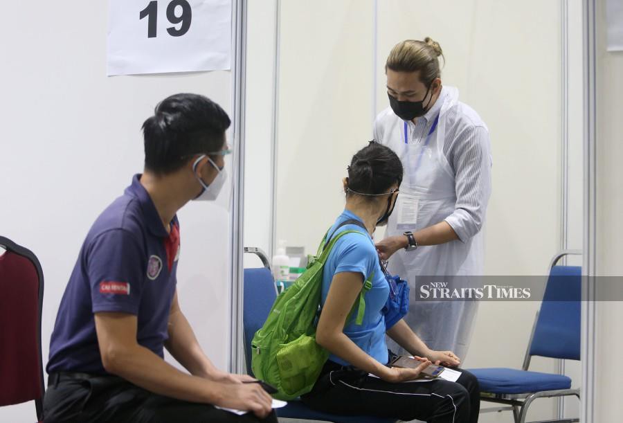 A medical officer administers Covid-19 vaccine at the Kuala Lumpur Convention Centre (KLCC) vaccination centre in Kuala Lumpur on Aug 2. - NSTP/MOHAMAD SHAHRIL BADRI SAALI