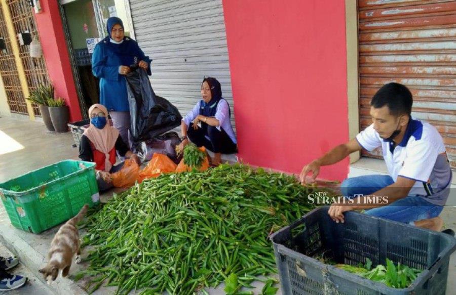Vegetables being packed for delivery the same day to ensure they are fresh, said Norapan (second from left). - Pic by Zainal Aziz