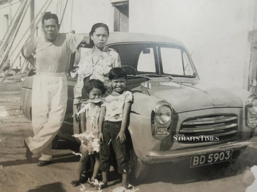  Lat with his parents and sister Maimunah along with his father's Ford Anglia at Mentakab, 1958.