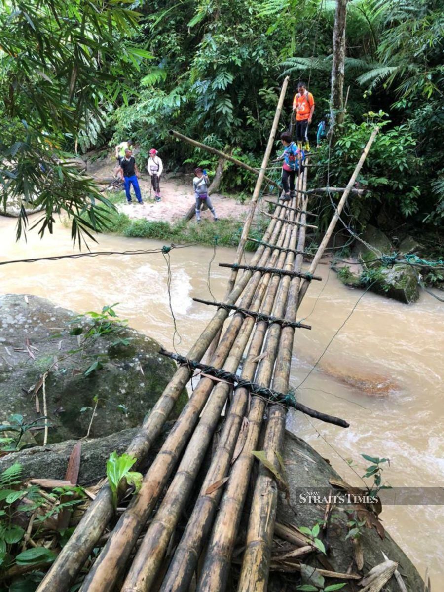  Rickety bamboo bridge over a fast flowing stream.