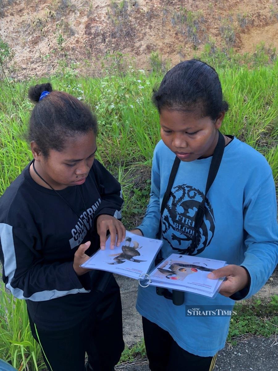  Asmah a/p Kumbang and Lembut a/p Aming learning how to identify birds.