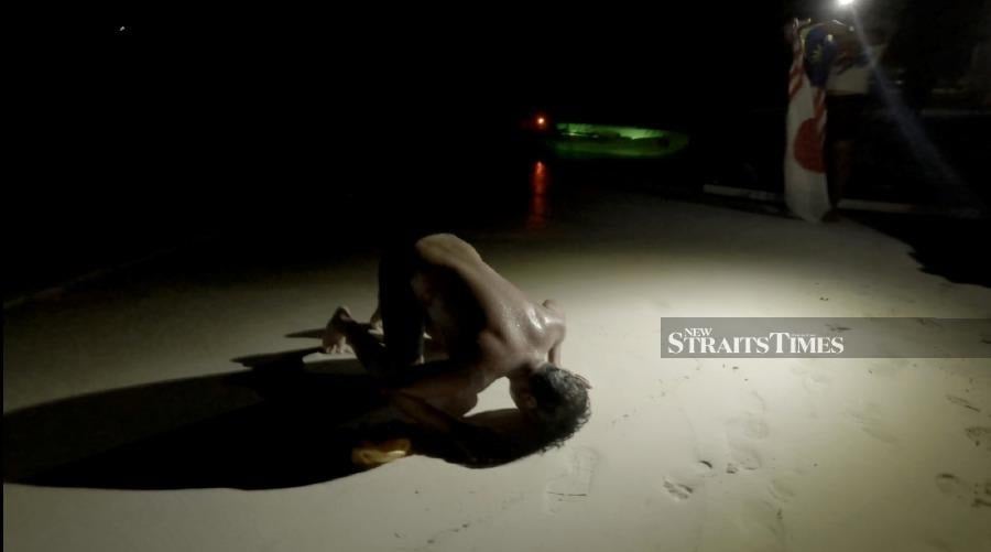  Ridzwan prostrating in gratitude upon landing at Arwana Perhentian Resort, Pulau Perhentian Besar.