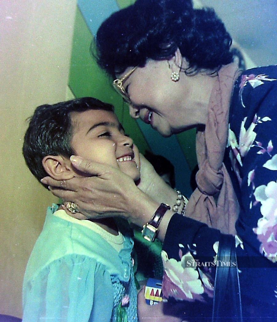  A delighted child during a meeting with Tun Dr Siti Hasmah in an orphanage.