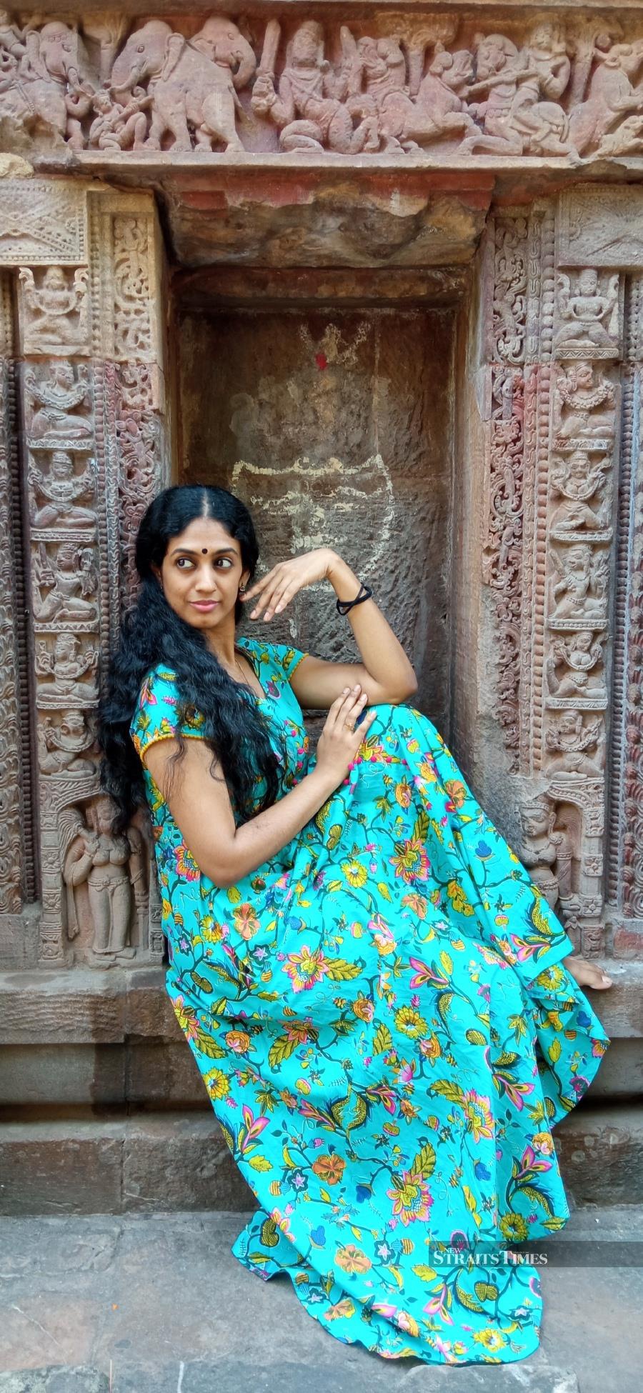  Geethika Sree, the assistant to the artistic director posing against the backdrop of a temple sculpture.