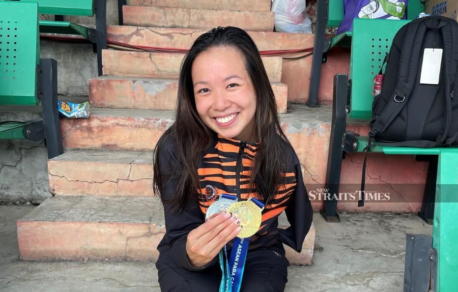  A jubilant Carmen Lim posing with her medal hauls.