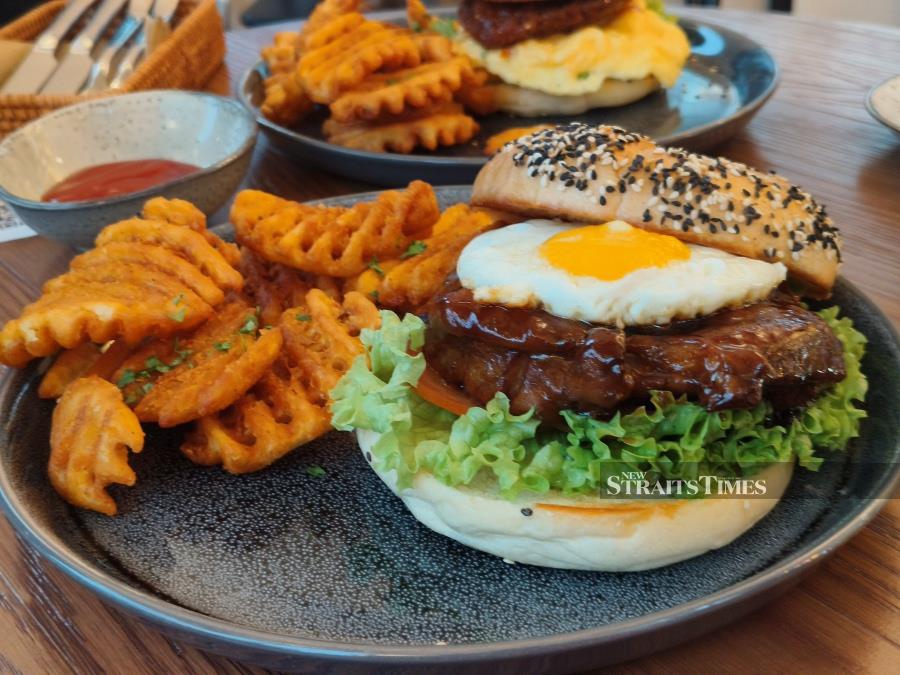  Terikyaki chicken burger served with bagel buns and waffle fries.