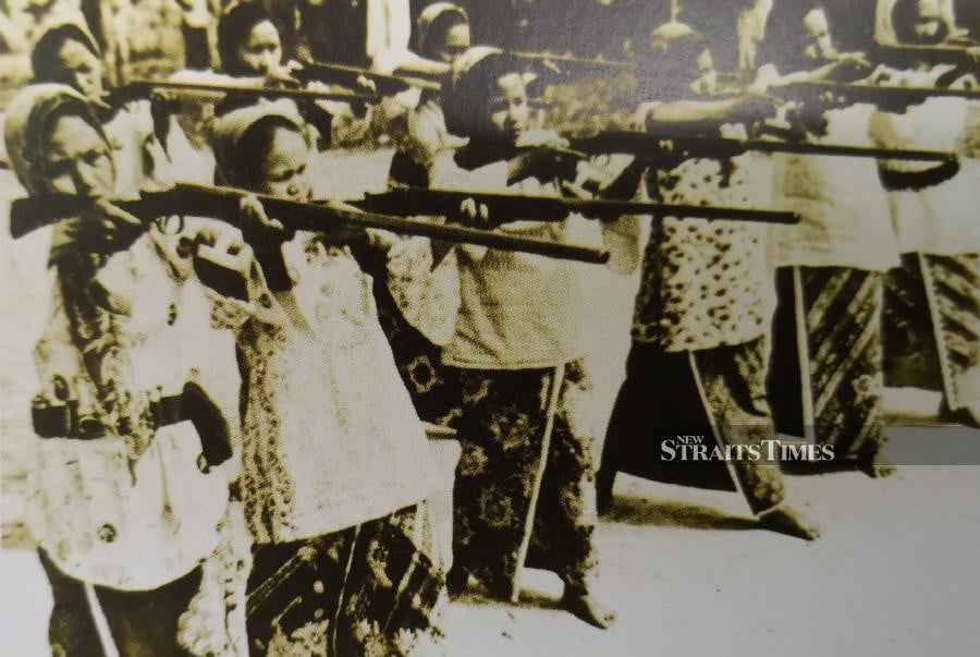  Baju kurung-clad Malay women trained to use firearms to protect their homes during the Malayan Emergency.