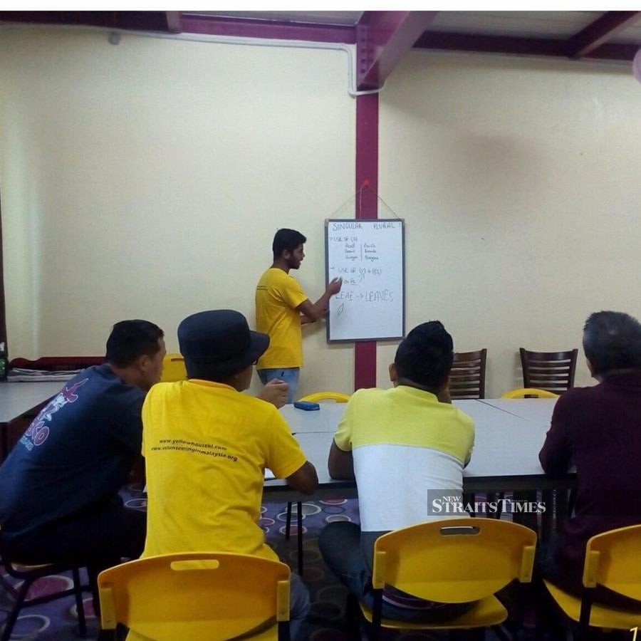  Yellow House volunteers teaching conversational English to homeless beneficiaries at Pusat Transit Gelandangan, a homeless transit centre.