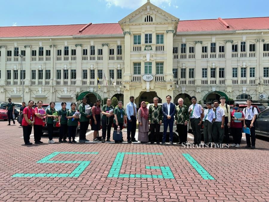  The writer with the SGI board of management president Joseph Lau, Paul Low and principal, teachers and students of St George's Insitution of Taiping.