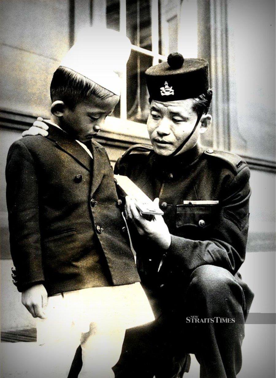  Rambahadur Limbu showing his 5-year-old son the Victoria Cross he received at Buckingham Palace.