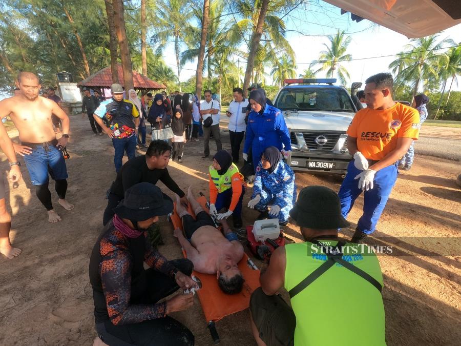  Ridzwan being attended to by an ambulance crew from the Malaysia Civil Defence Force upon arrival at Bari beach.